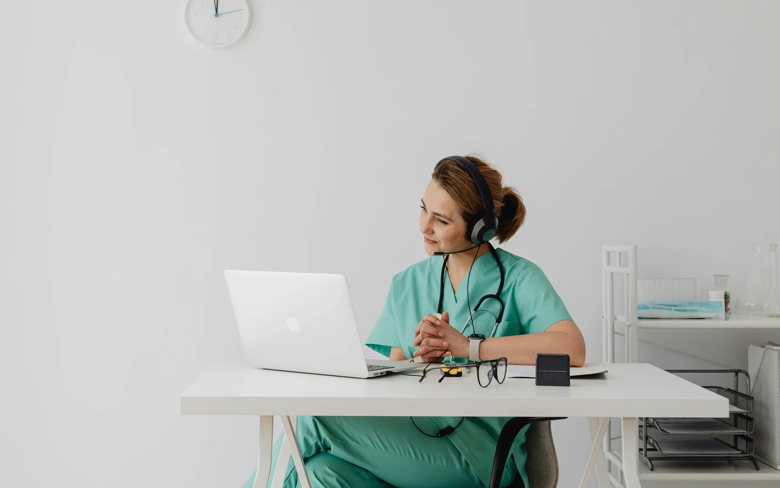 Clinician wearing a headset during a telehealth laptop consultation